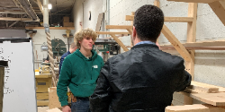 Reporter interviews student in a wood shop