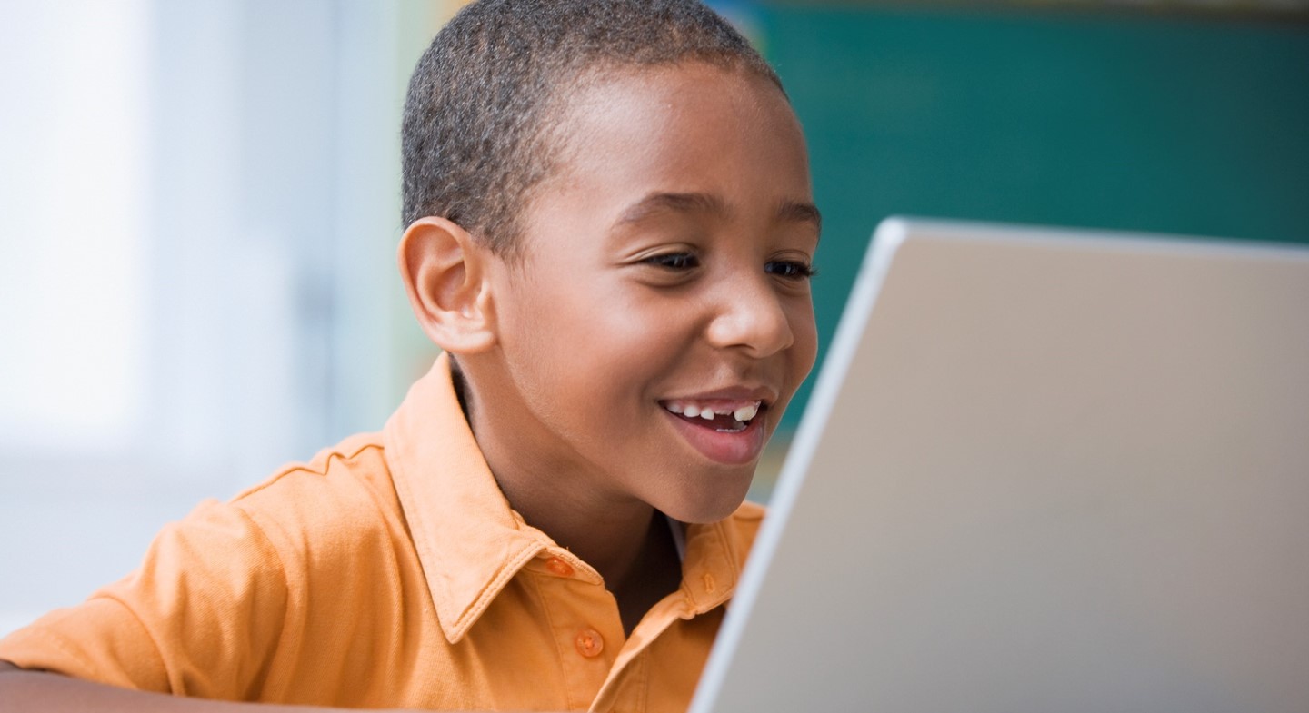 Child smiling on laptop