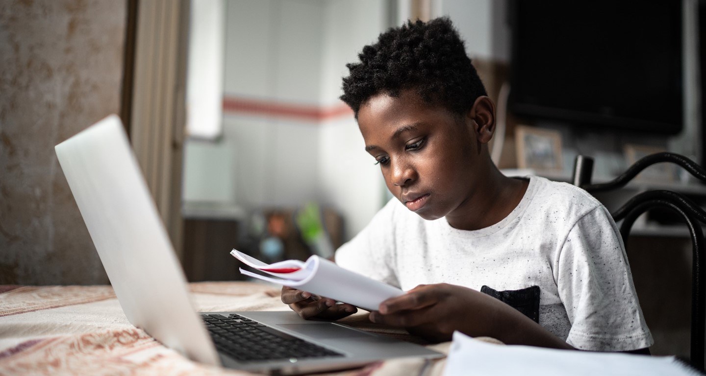 Boy reading with laptop