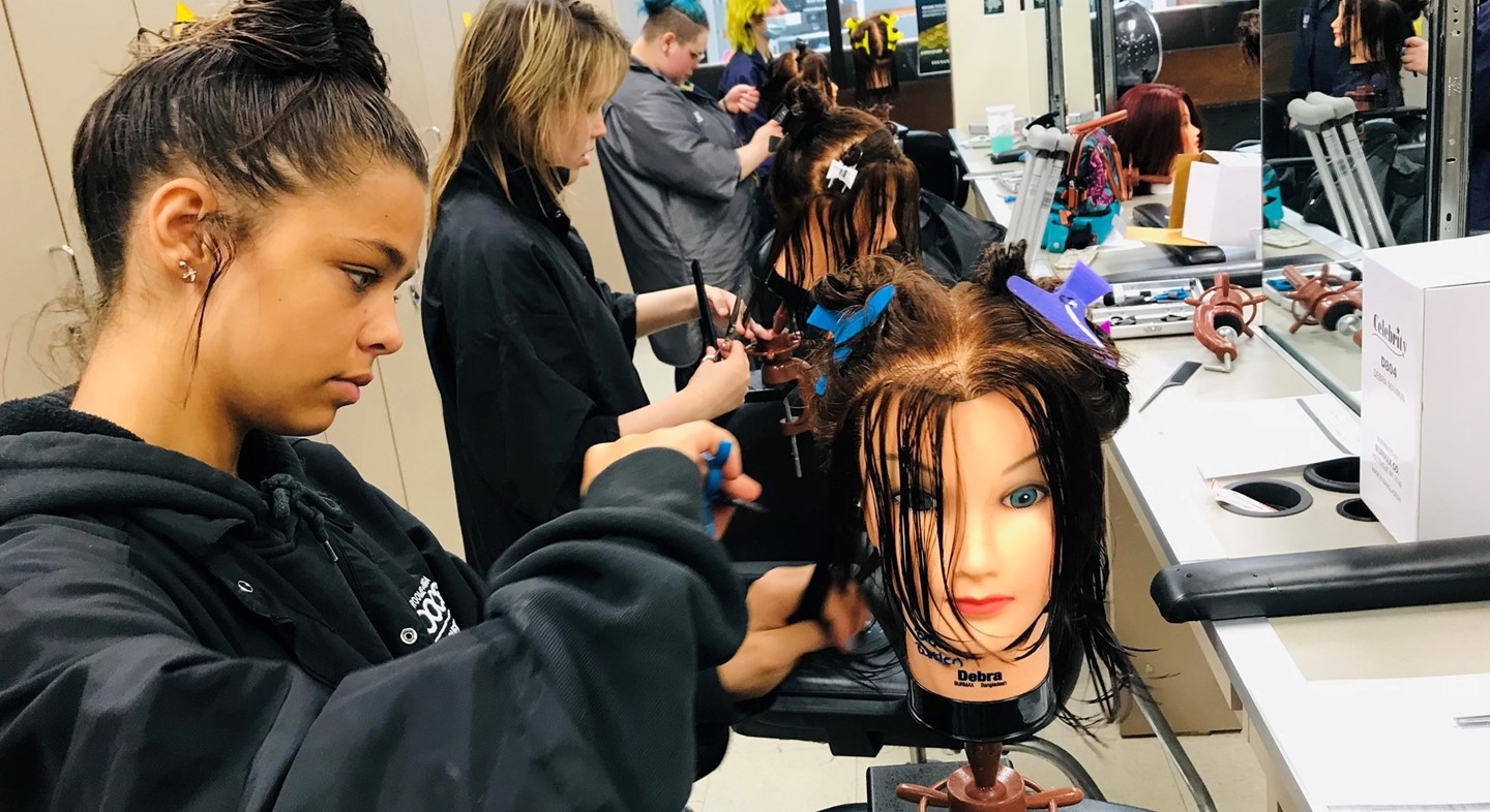 Students learning to cut hair