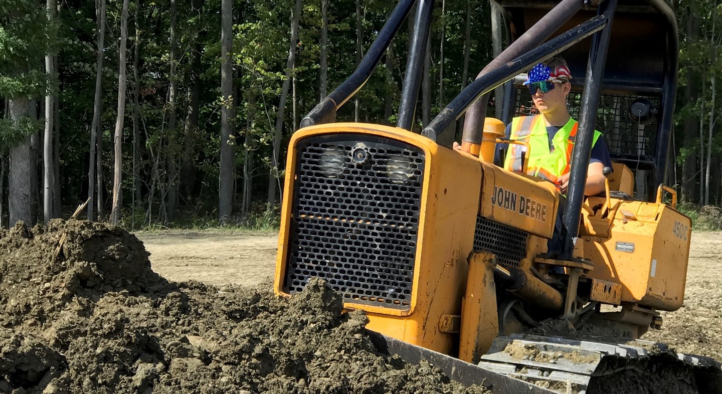 Student operating tractor