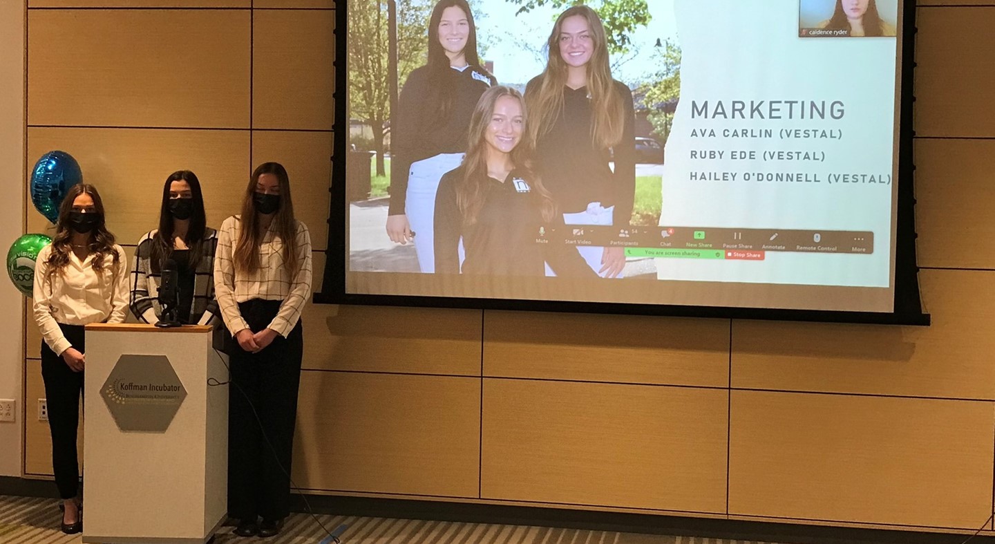 Students presenting in front of screen