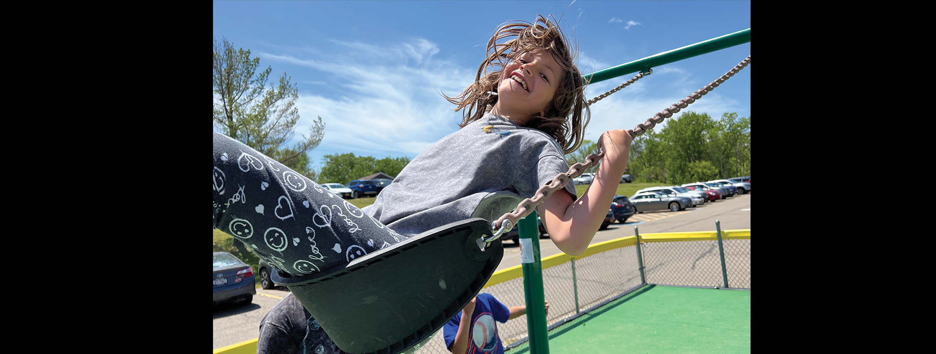 child swinging on swing smiling