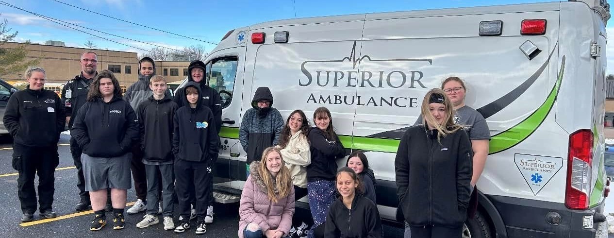 PTECH health group photo in front of ambulance