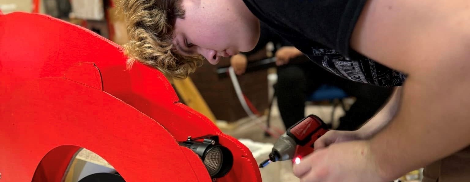PTECH student building light display for Roberson